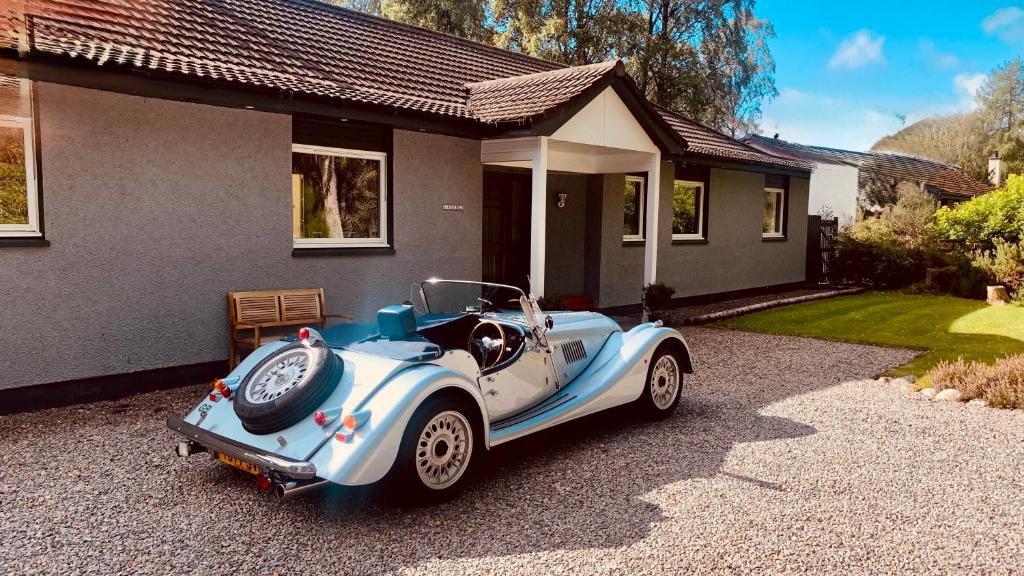 a blue and white car parked in front of a house at Craigdarroch Guest House in Contin