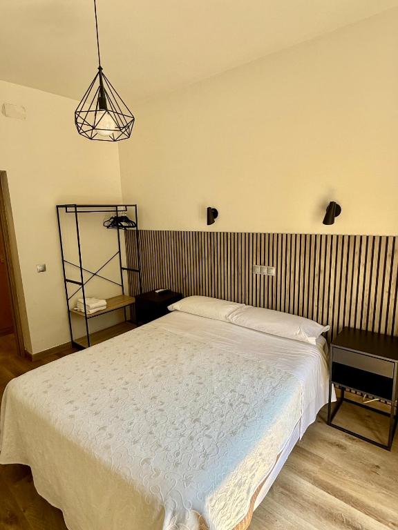 a bedroom with a white bed and a lamp at Hostal Fernández Atocha in Madrid