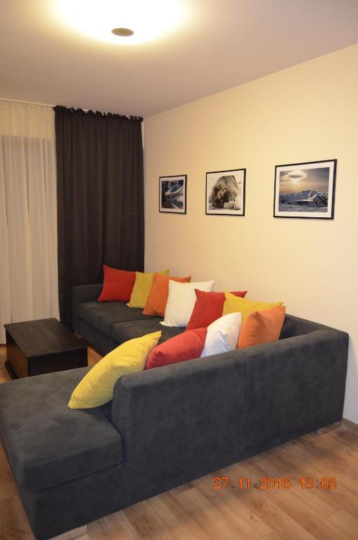 a living room with a couch with colorful pillows at New Gudauri 3 Apartment in Gudauri