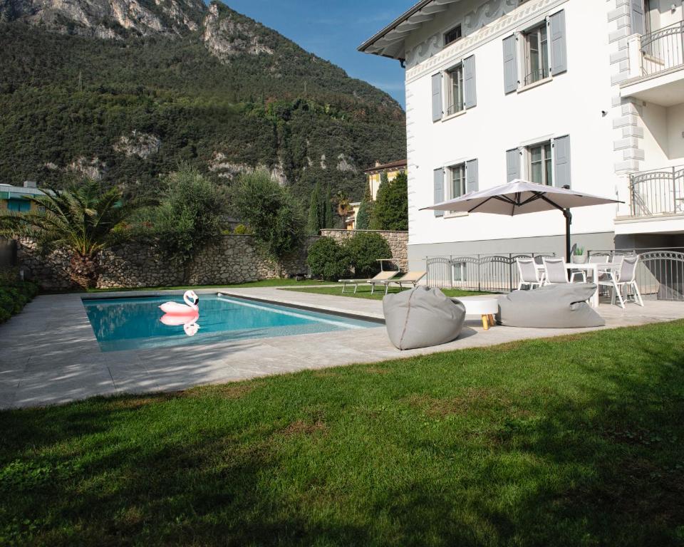 a swimming pool in front of a building with a house at Da Franca in Riva del Garda