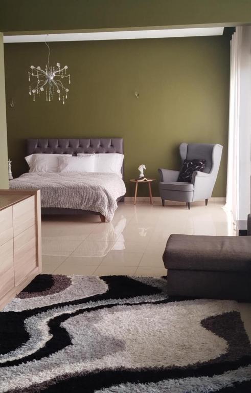a bedroom with a bed and a couch and a chair at Grace, fifteen minutes drive away from the beach in Kolymvari