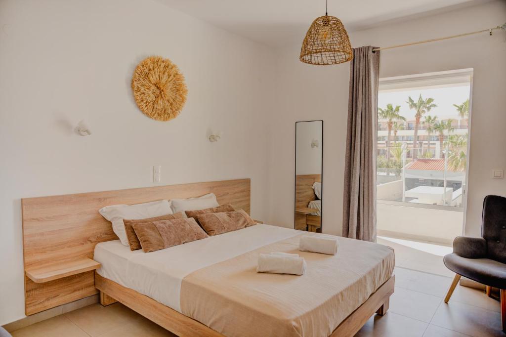 a bedroom with a large bed and a chair at Indigo Seaside Experience in Adelianos Kampos
