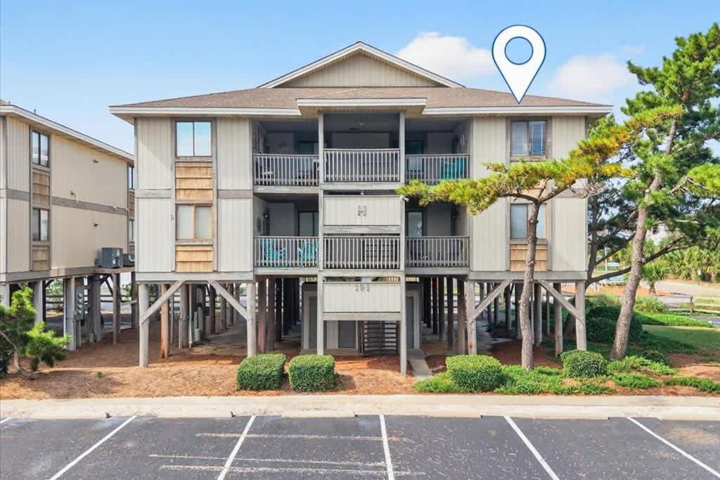 a large apartment building with a parking lot at Castle By The Sea Beach Front Condo in Ocean Isle Beach