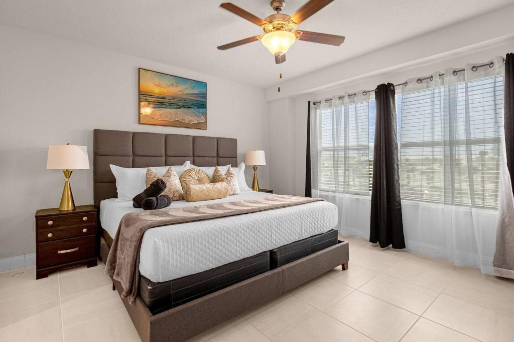a bedroom with a bed and a ceiling fan at Beachfront Condo with Spacious Balcony in Daytona Beach