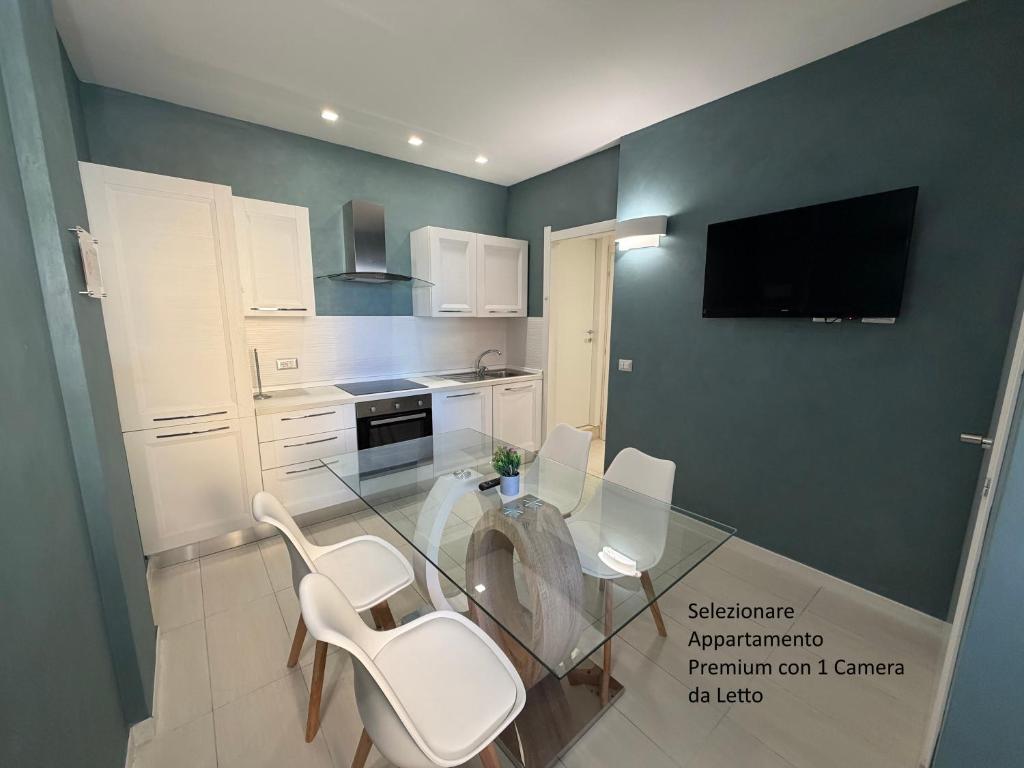 a kitchen with a glass table and white chairs at The Smerald in Alghero