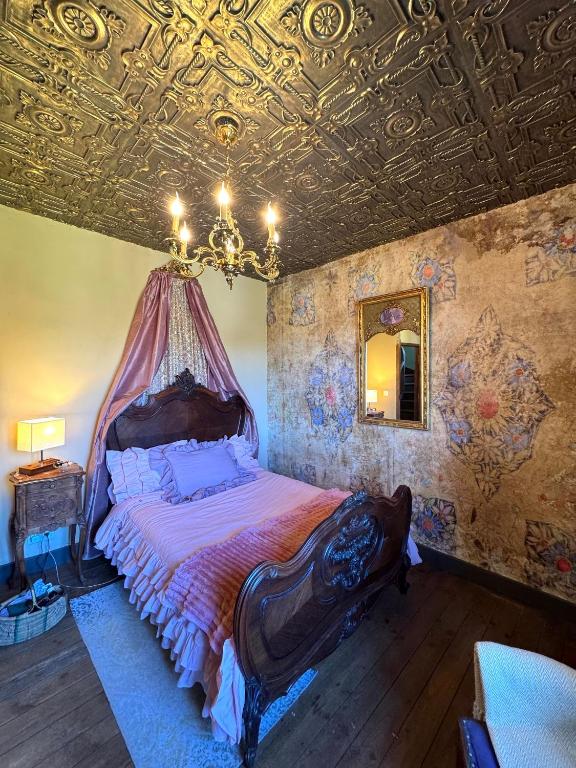 a bedroom with a bed and a ceiling with a chandelier at Charming BB Room in Historic Saint-Martial-le-Mont, Creuse in Saint-Martial-le-Mont