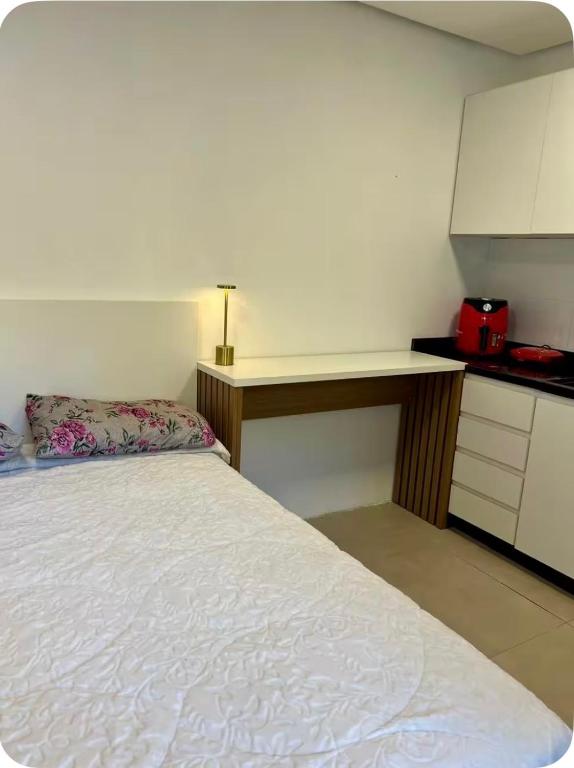 a bedroom with a white bed and a counter at Suíte completa com cozinha próximo ao mar in Torres