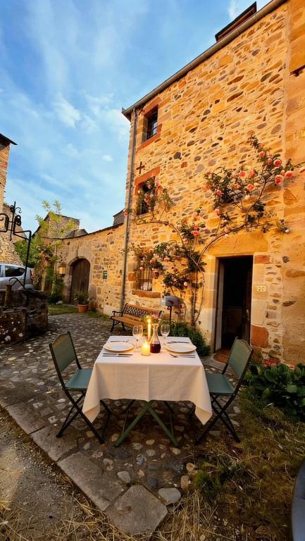 a table and chairs in front of a building at Le Puits Enchanté in Espalion