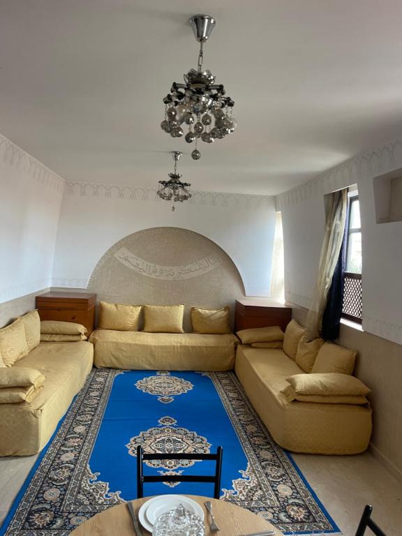 a living room with a couch and a chandelier at Appartement Marrakech in Marrakesh