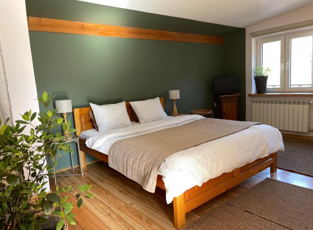 a bedroom with a bed and a green wall at Zielony Pokój in Ojców