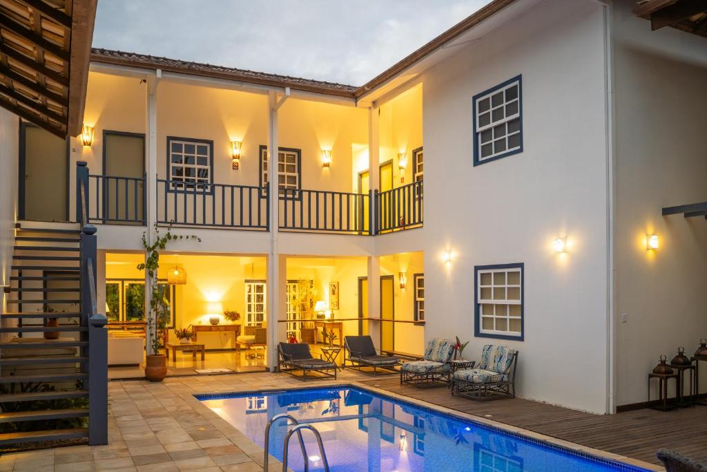 a house with a swimming pool in front of it at Casa Poema Paraty in Paraty