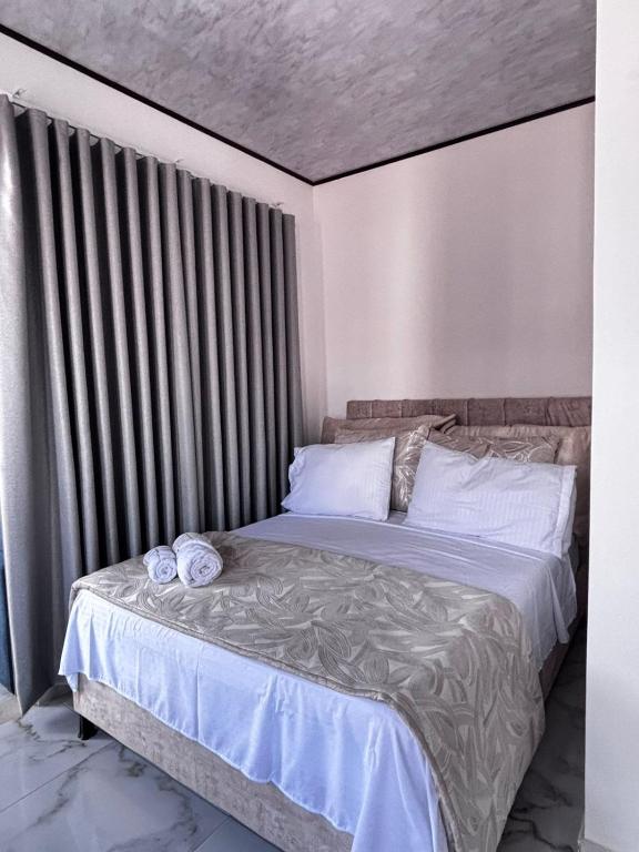 a bedroom with a large bed with white sheets at Aparta Hotel La Osadía in Acacías
