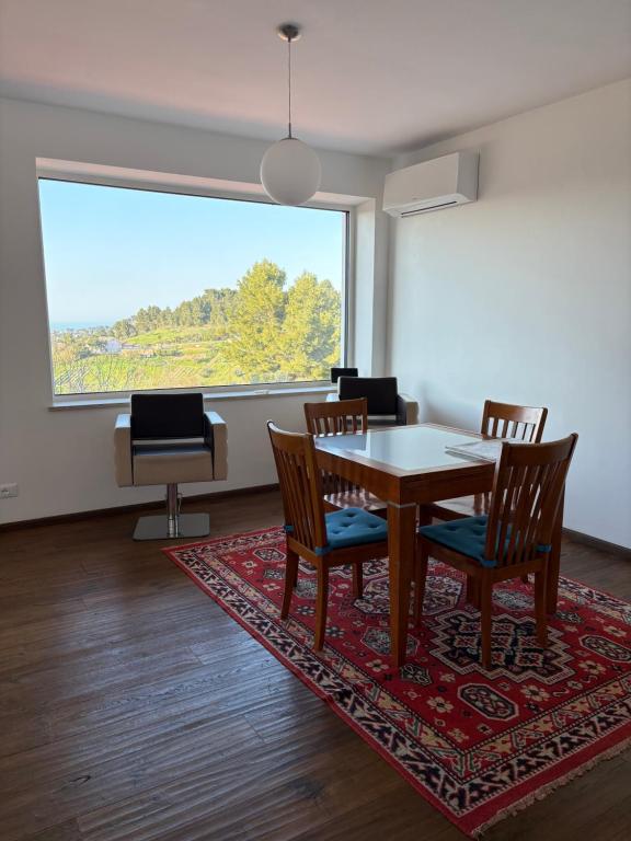 a dining room with a table and chairs and a large window at B&B Azzurra in Pescara