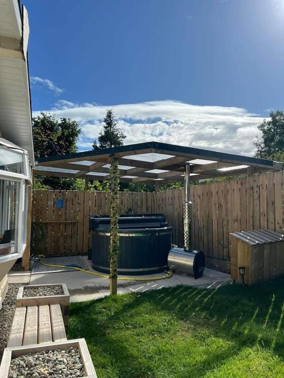 eine Terrasse mit einem Vordach über einem Zaun in der Unterkunft Hideaway21 in Maghera
