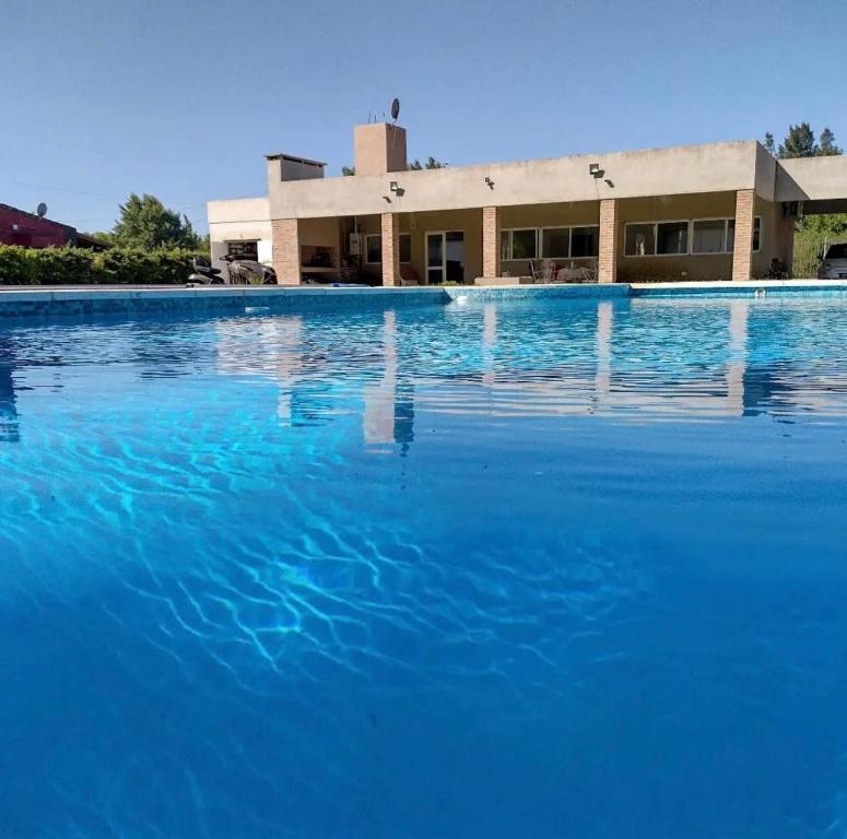 a large pool of blue water in front of a building at La Casa de Mirko in San Nicolás de los Arroyos
