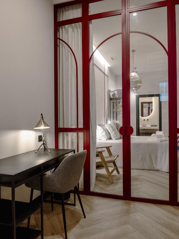 a room with a desk and a bedroom with a bed at Castelar Urban Suites in Badajoz