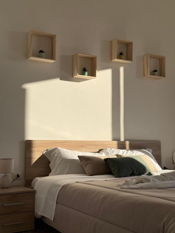a bedroom with a large bed with two shelves on the wall at Appartamento familiare in centro a due passi dai trulli - Casa Costanza in Alberobello