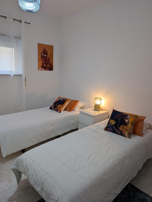 two beds in a white room with at Cozy rooms in Minde, Fatima in Minde