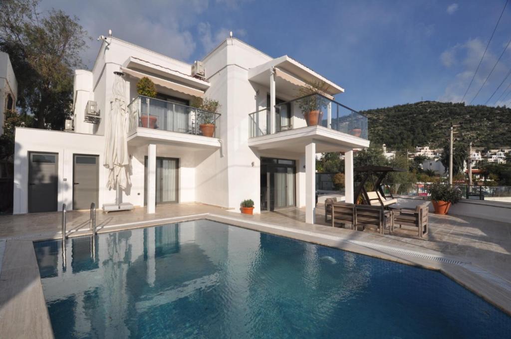 a white house with a swimming pool in front of it at Villa Port Bodrum in Bodrum City