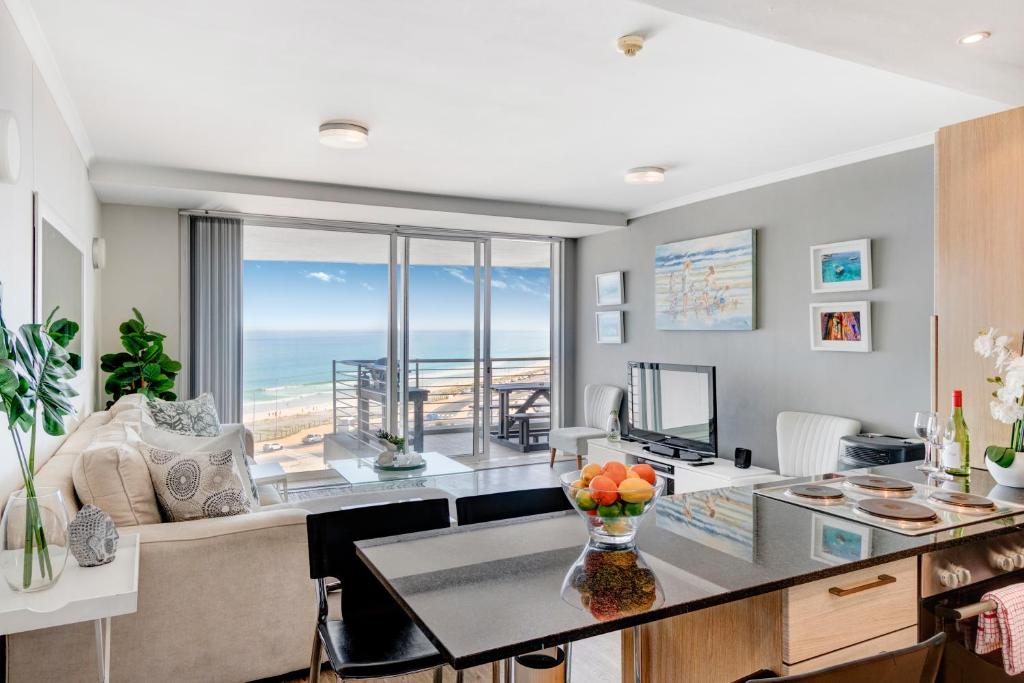 a living room with a view of the ocean at Cape Town, Blouberg Beachfront Luxury Apt - Kite Beach in Bloubergstrand
