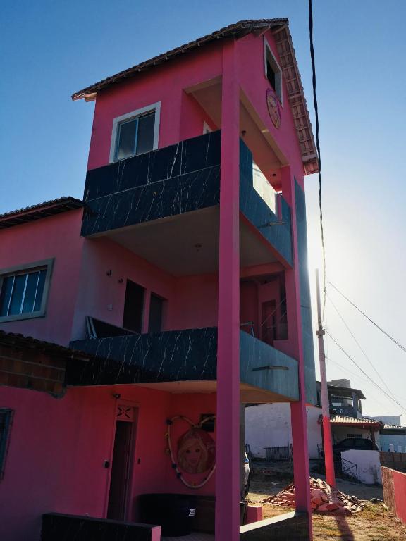 a pink building with balconies on the side of it at Casa da BARBIE Praia in Itapipoca