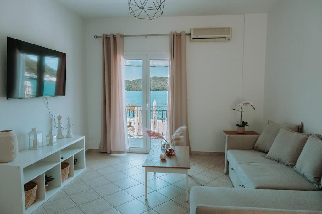 a living room with a couch and a table at Teal Seafront Home in Syvota