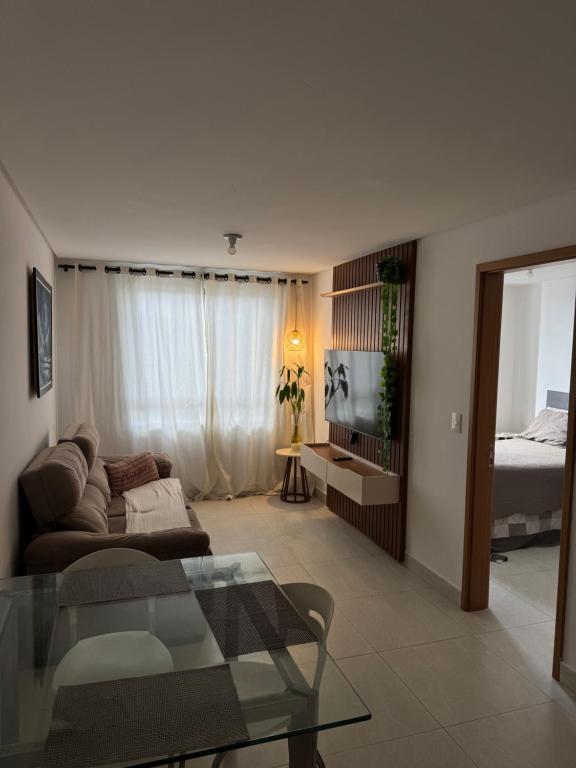 a living room with a couch and a glass table at Flat aconchegante com vista pro açude in Campina Grande