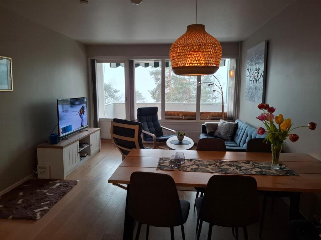 a living room with a table and chairs and a television at Apartment with a view at Tonsenhagen in Oslo