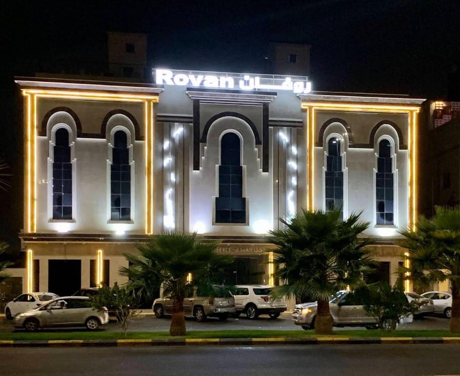 a building with cars parked in front of it at night at فندق روفان in Medina