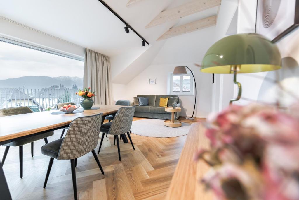 a living room with a table and chairs and a couch at Das Salzamt - Boutique Apartments in Gmunden