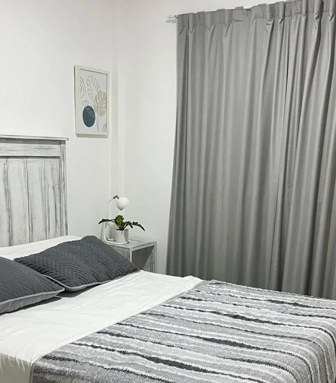 a bedroom with a bed with a gray curtain at Inehouse in Concepción del Uruguay