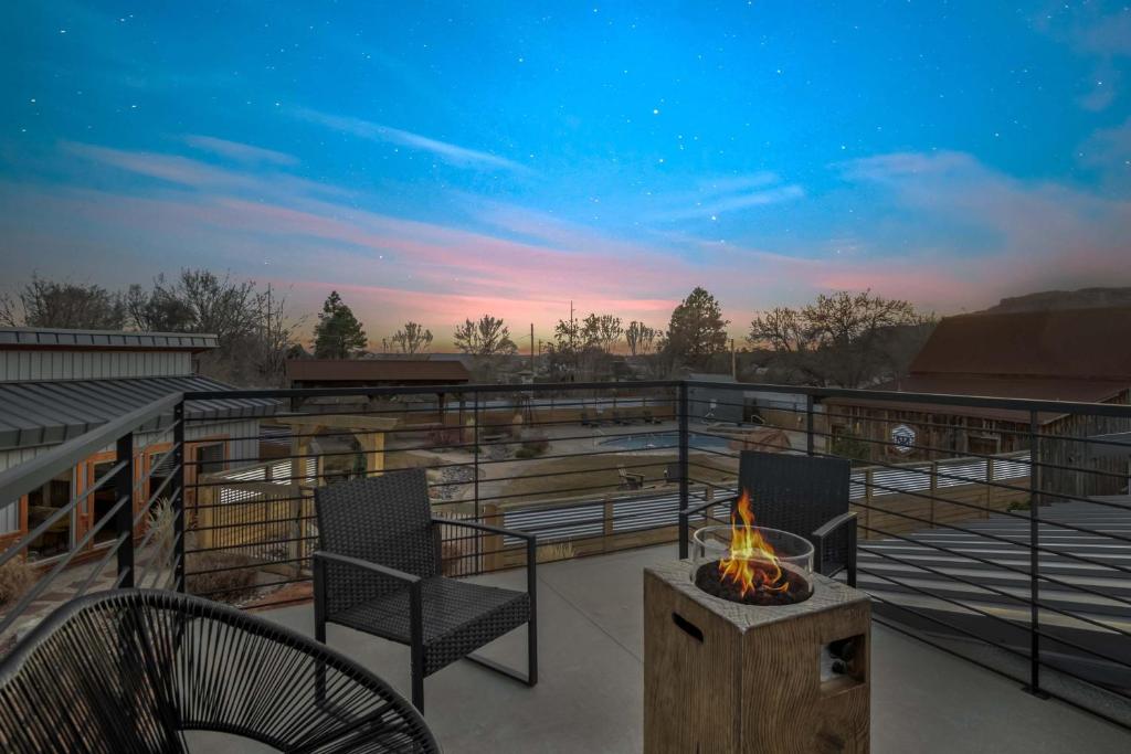a balcony with two chairs and a fire pit at Timber & Tin G 2Bed 2Bath w Pool & Rooftop Deck in Kanab