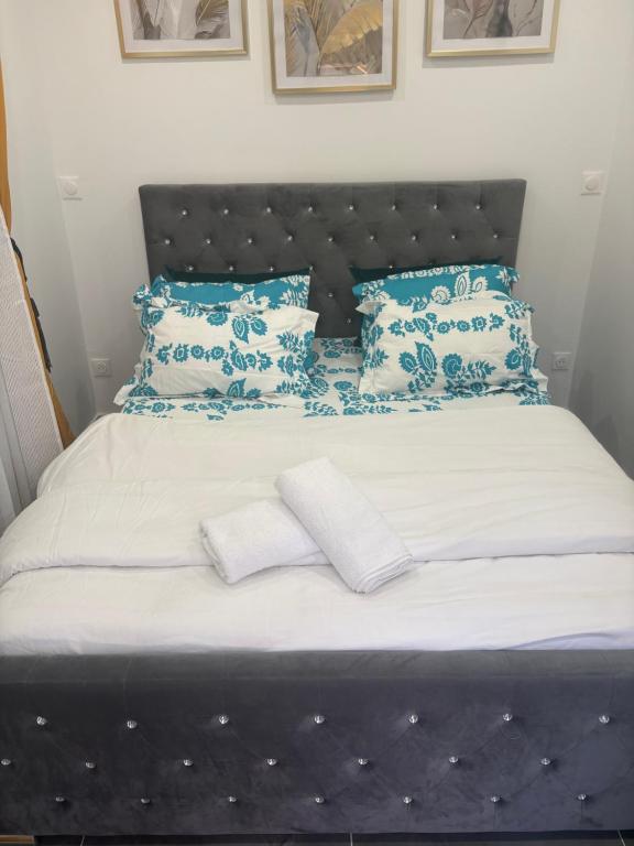 een bed met blauw-witte kussens erop bij Studio moderne in Salles