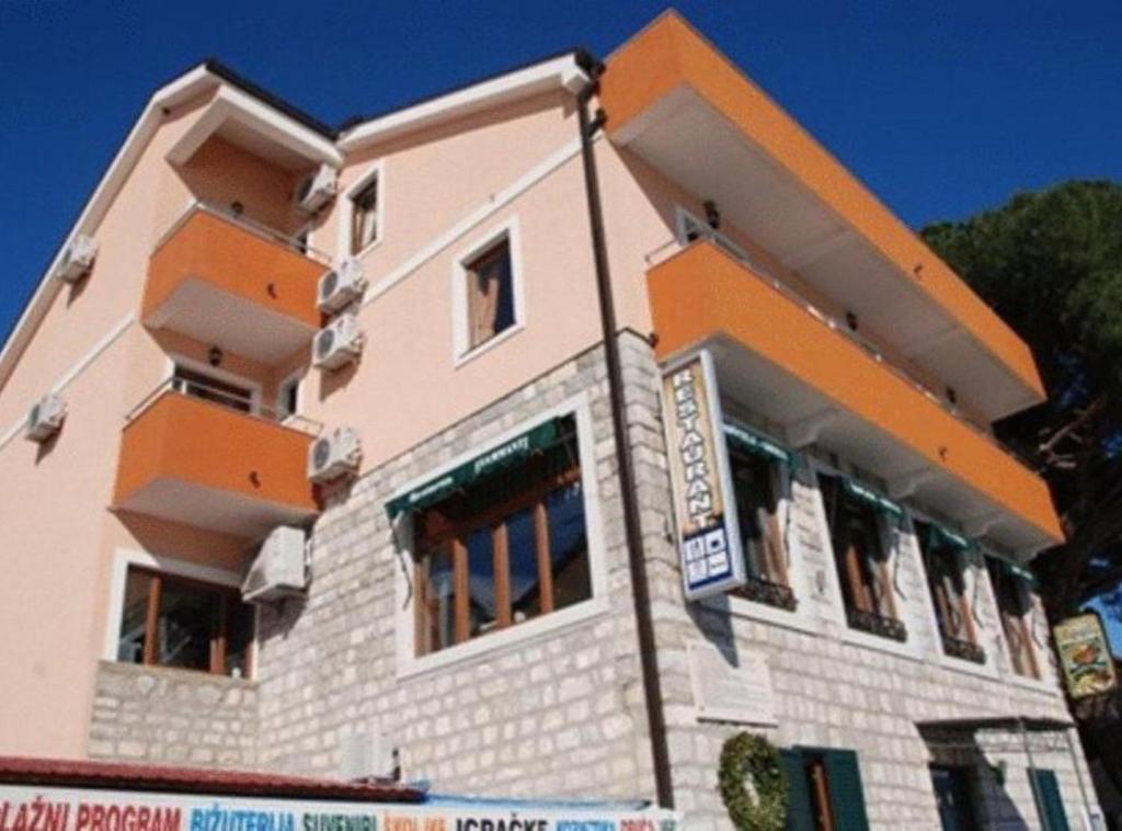 a building with an orange and white at Fiammanti Hotel Montenegro in Herceg-Novi