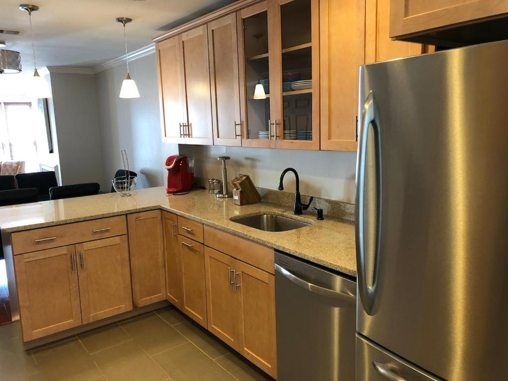a kitchen with a stainless steel refrigerator and wooden cabinets at Downtown house w on-site parking walk to museums, US Capital Scap in Washington, D.C.