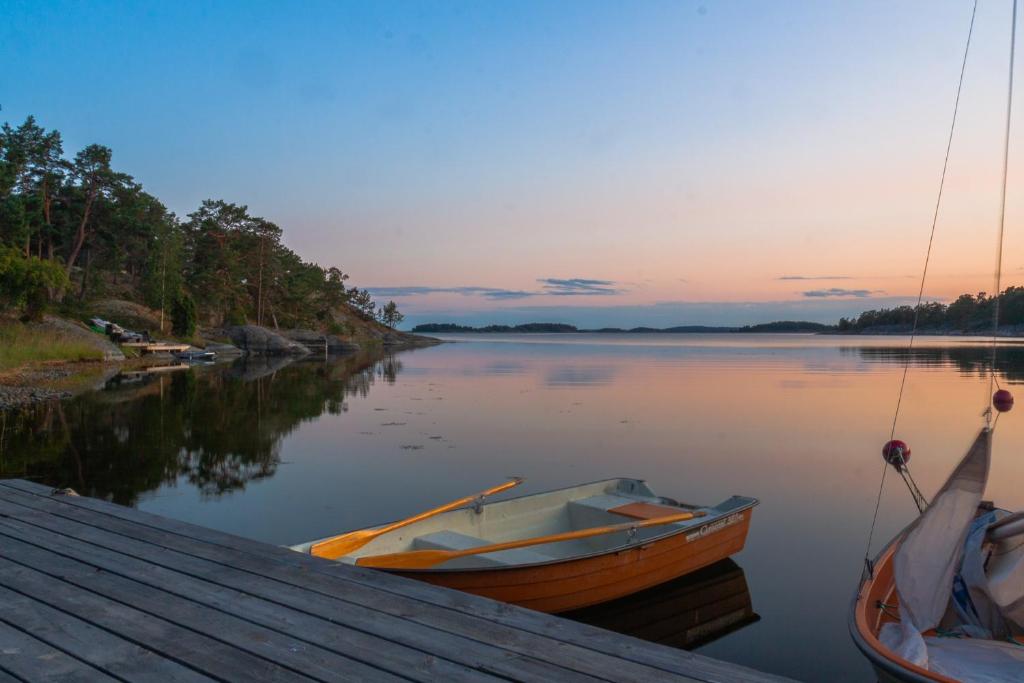 a boat is docked at a dock on a lake at Stunning Waterfront Property in the Outer Archipelago in Kyrkkobben