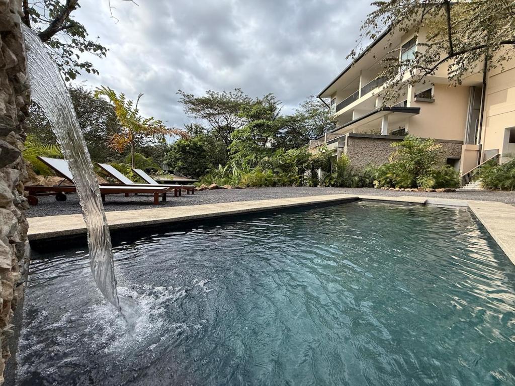 a swimming pool with a fountain in front of a building at Isabel 203 Space, light and calm! in Nicoya