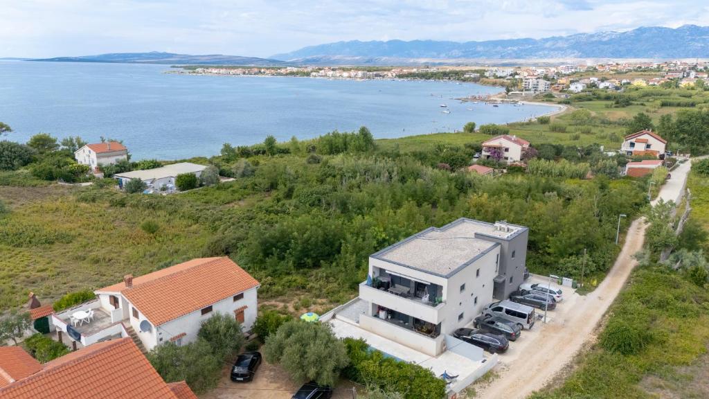 an aerial view of a house on a hill next to the water at Premium Apartment Obatnice with Pool in Povljana