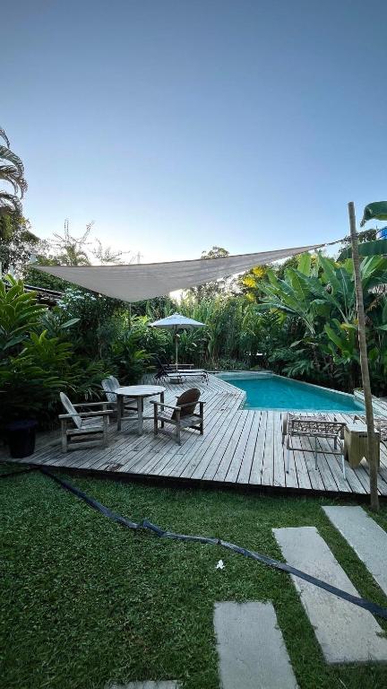 a patio with a table and chairs and a pool at Biribandos Rooms - a 300 metros do Quadrado e 900 metros das praias in Trancoso