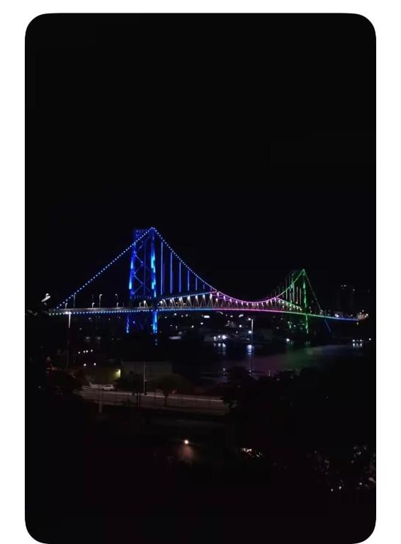 a blue and green bridge lit up at night at Ponte Hercílio Luz in Florianópolis