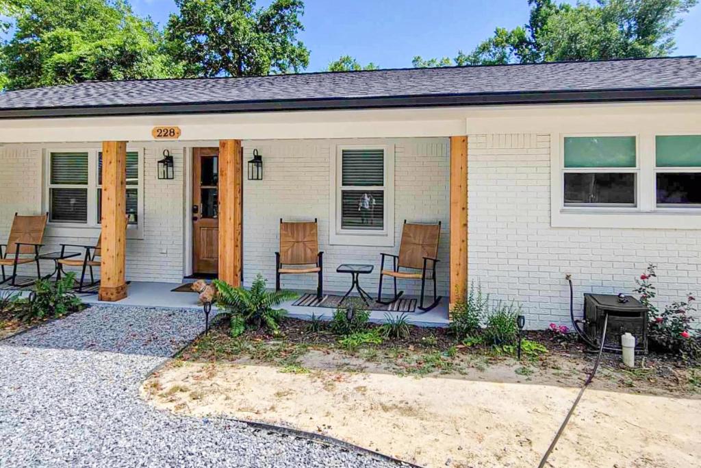 a house with a porch with chairs and a table at Mardi Gras Parade, Walk to Beach! Bay St Louis Gem in Bay Saint Louis