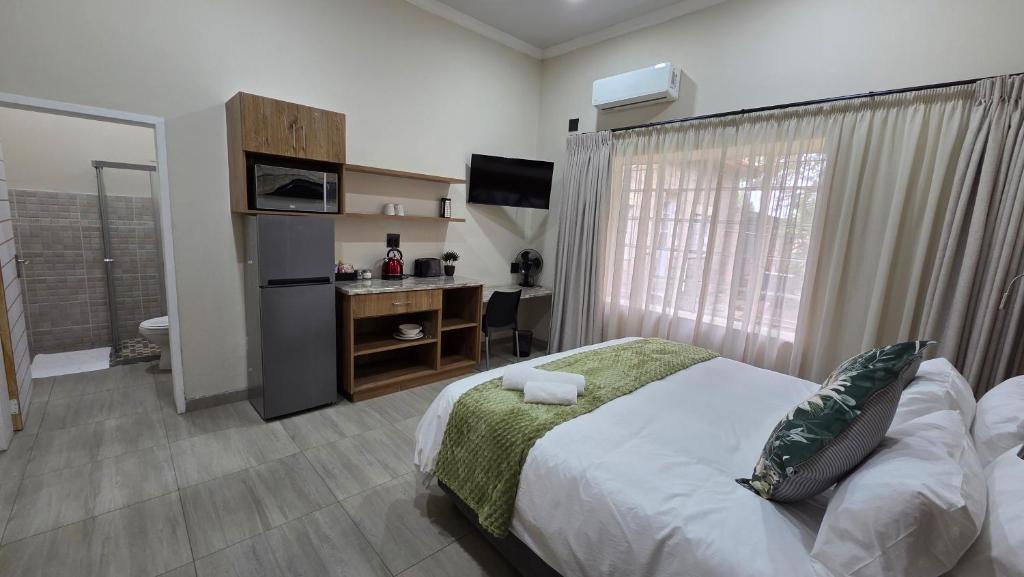 a bedroom with a bed and a desk and a window at Morgenzon Lodge in Morgenzon