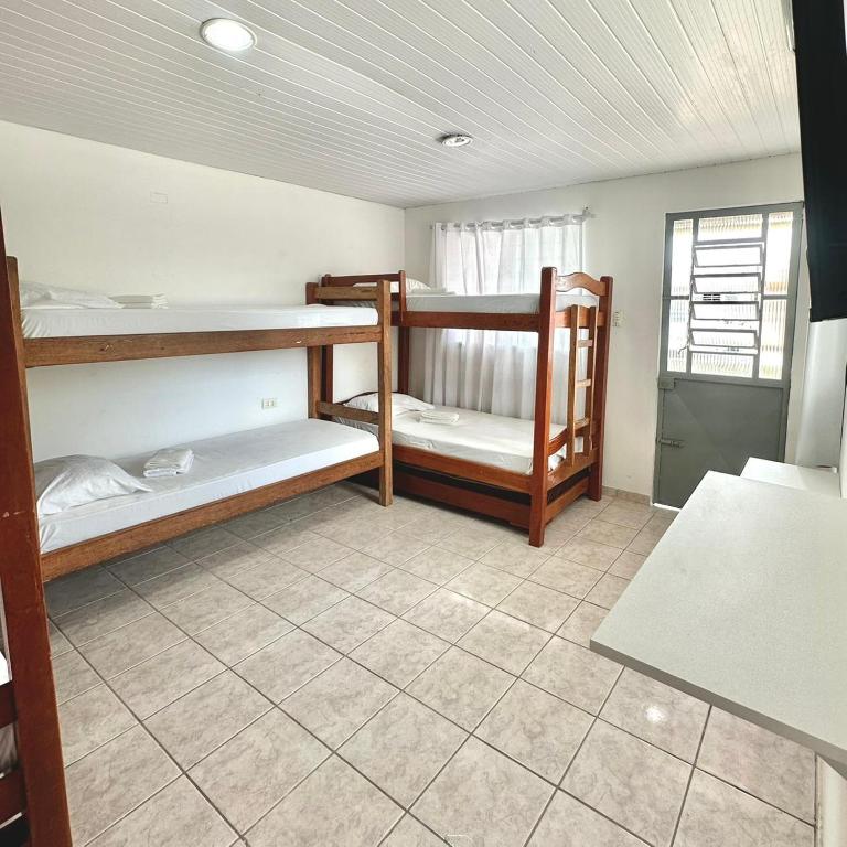 a room with three bunk beds and a window at Anexo - Pousada Canaã in Recife