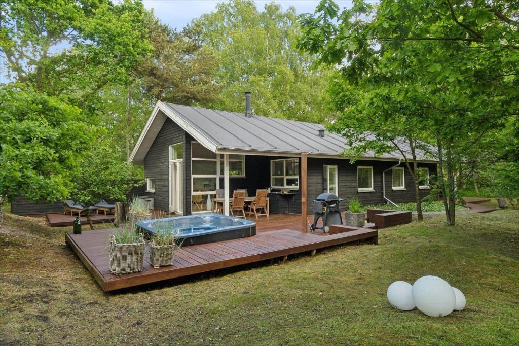 a small house with a hot tub in the backyard at 8571-Grenaa-Kaprifolievej-20 in Grenå Strand