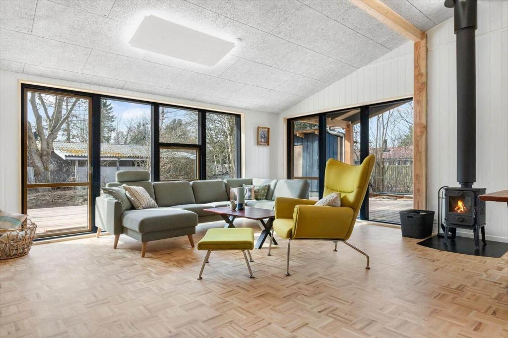 a living room with a couch and chairs and a fireplace at 8882-Glesborg-Kaervejen-5 in Fjellerup Strand