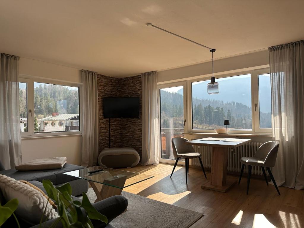 a living room with a table and a large window at Ferienwohnung Bergidyll in Schönau am Königssee