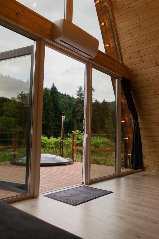 an open glass door to a deck with a view at Skala House in Skole
