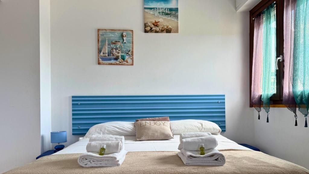 a bedroom with a bed with two towels on it at Le casette di Frà Studios in Santa Severa