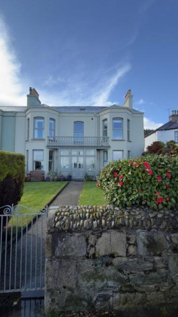 a large white house with a fence and flowers at Dacara Bed & Breakfast in Newcastle