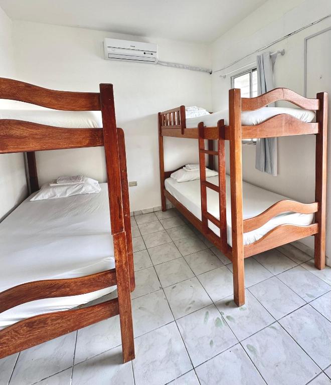 a room with three bunk beds and a window at Anexo Térreo - Pousada Cannã in Recife